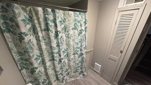 A bathroom with a shower curtain, toilet, and bathtub. - Cozy Private Studio w/ Kitchenette (Pittsburgh)