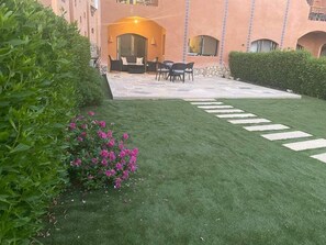 A well-maintained outdoor area with a patio, seating, and a hedge. - Family place in haicnda ras sudr (la hacienda ras sudr)