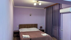 Une chambre d’hôtel avec un lit, une table de chevet, une table et une chaise.