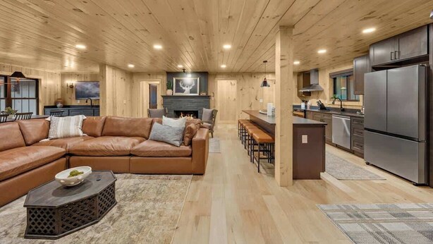 A spacious living area with a leather sofa, a coffee table, and a fireplace. - Pool•Riverfront Cabin•Walk to Gatlinburg Strip (Gatlinburg)