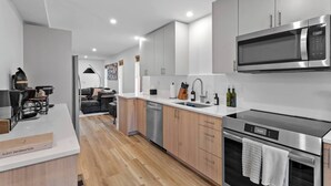Uma cozinha moderna com eletrodomésticos de aço inoxidável, armários de madeira e uma ilha central.