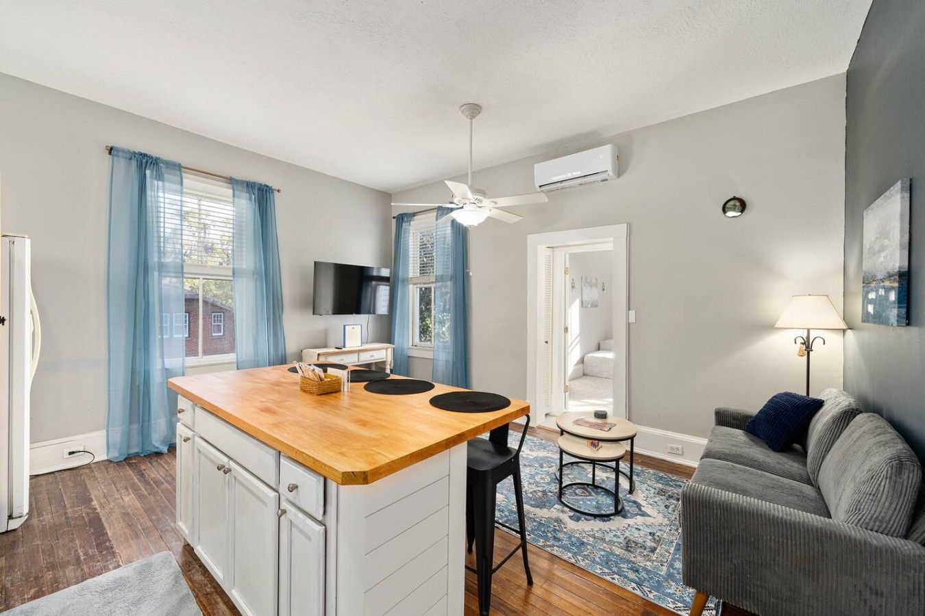 Een ruimtelijk ingerichte leefruimte met kitchenette, eethoek en zithoek.