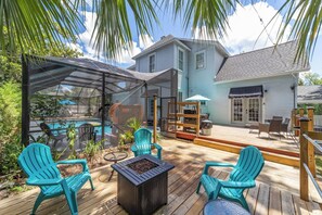 A covered outdoor deck with a pool, chairs, and a grill area. - Historic downtown 2/1 upper floor suite w/pool (Ocala)