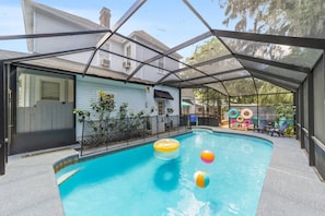 An indoor swimming pool with a covered area, surrounded by a fence, and equipped with inflatable rings and a beach ball. - Historic downtown 2/1 upper floor suite w/pool (Ocala)