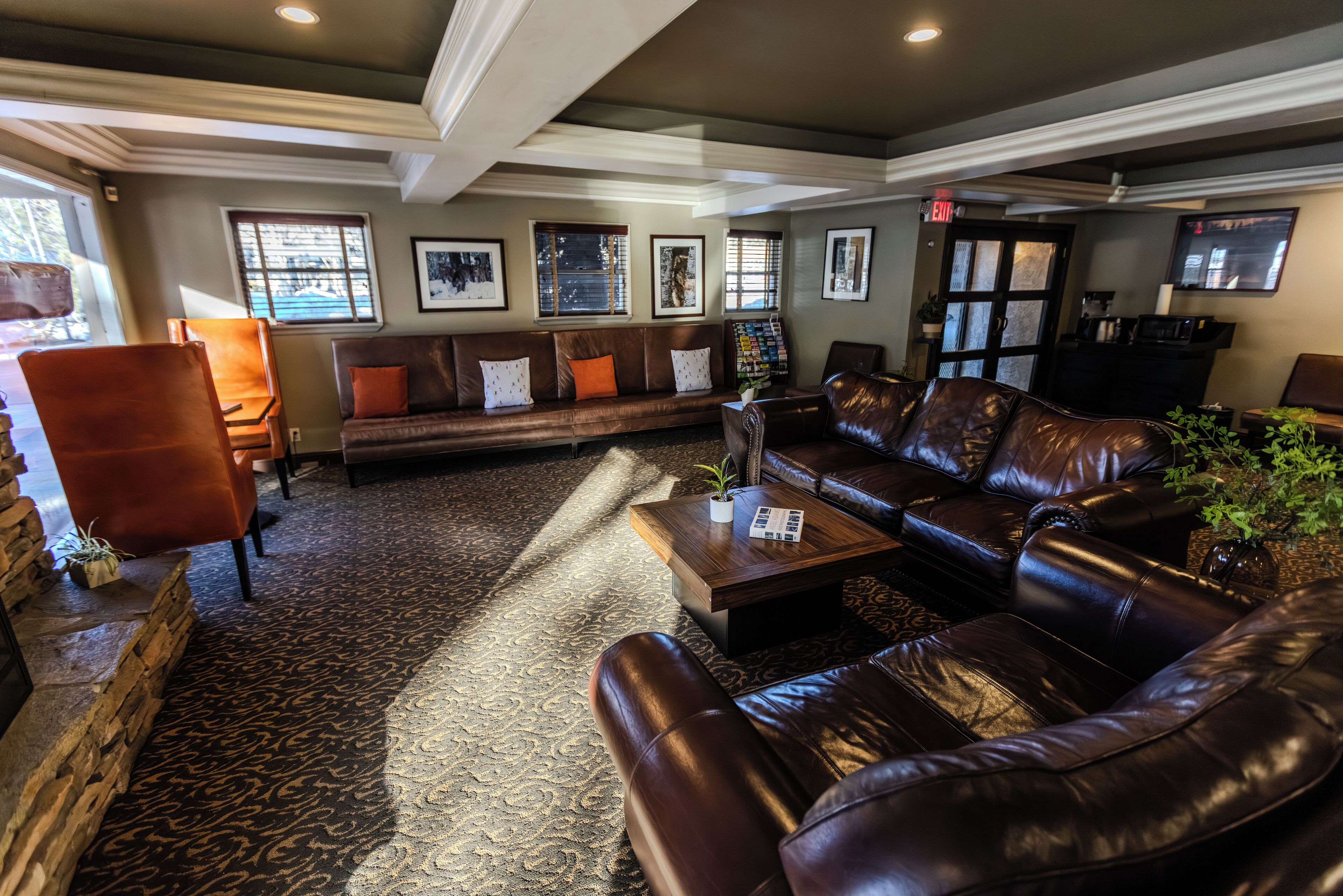 A spacious lobby with leather sofas, a coffee table, and framed artwork on the walls.
