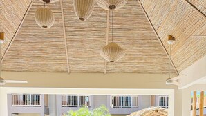 Eine moderne Küche mit Gasherd, ein Poolbereich mit Liegestühlen und eine Decke mit gewebten Mustern.