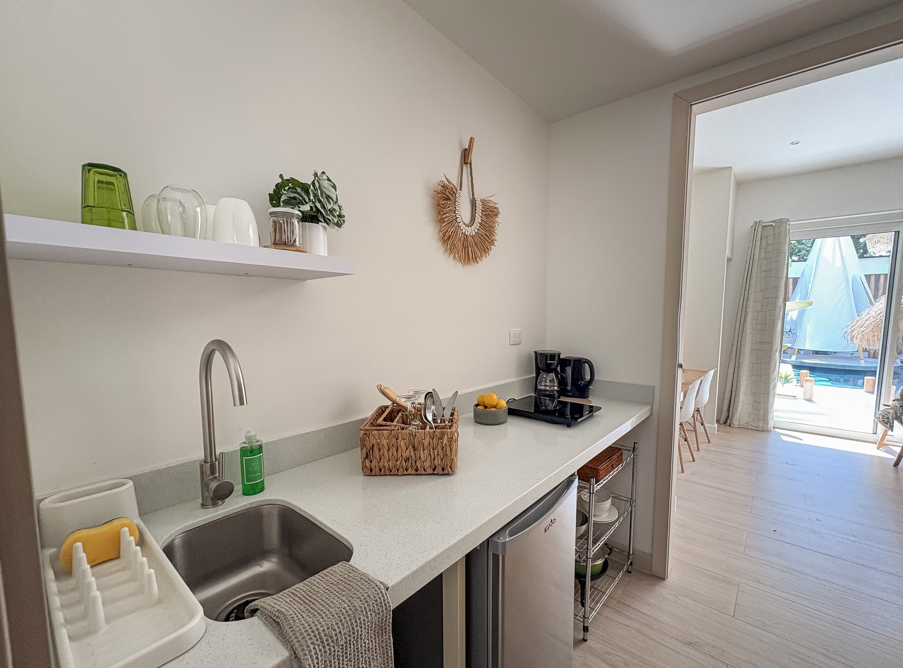 A modern kitchen with a built-in dishwasher, a coffee maker, and a sink.