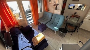 Ein gemütlicher Wohnraum mit einer Couch, einem kleinen Tisch und einer Heizung.