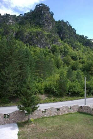 Una carretera con un muro de piedra y una zona cubierta de césped.