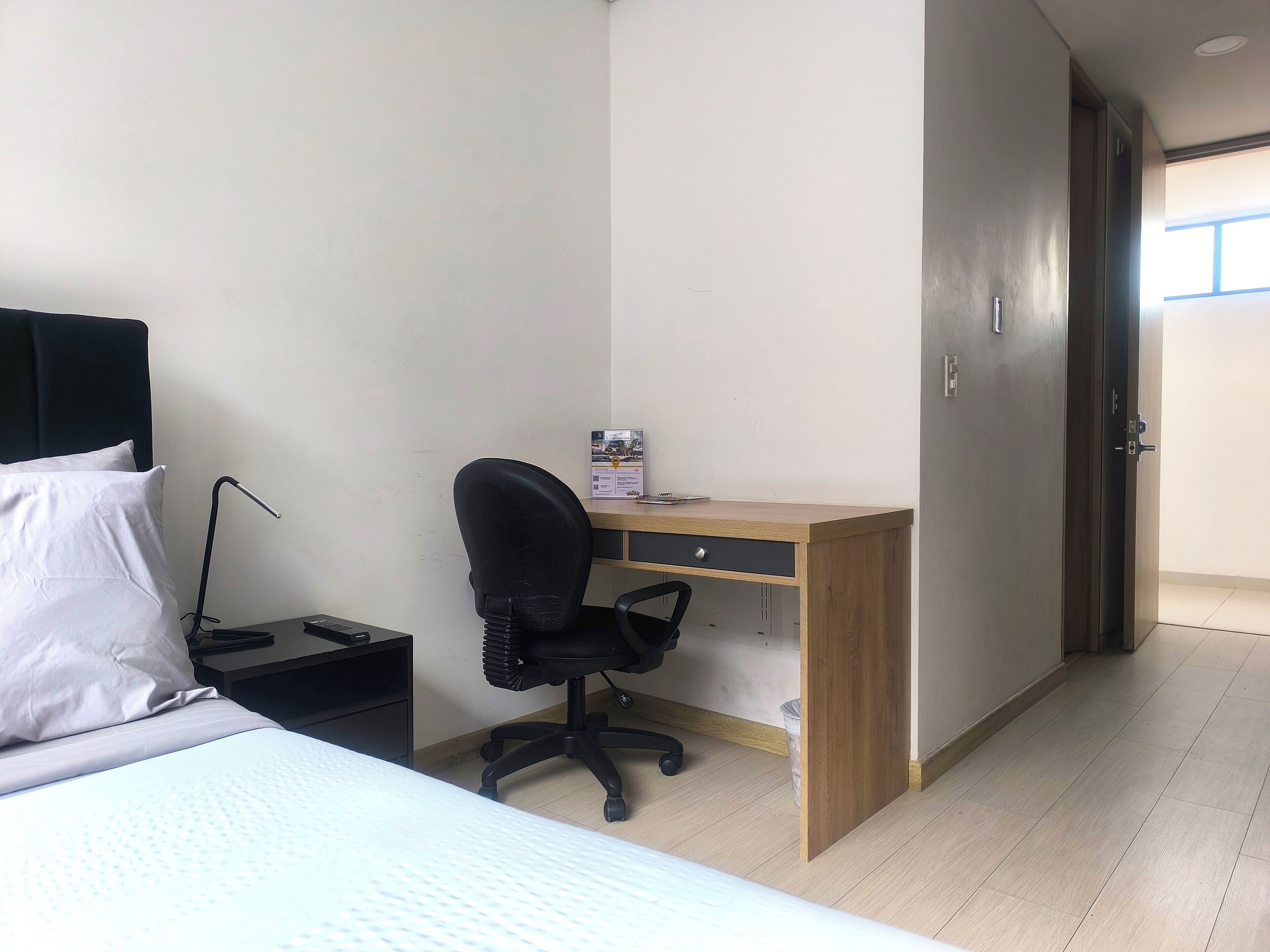 Un dormitorio con cama, escritorio, silla y armario.