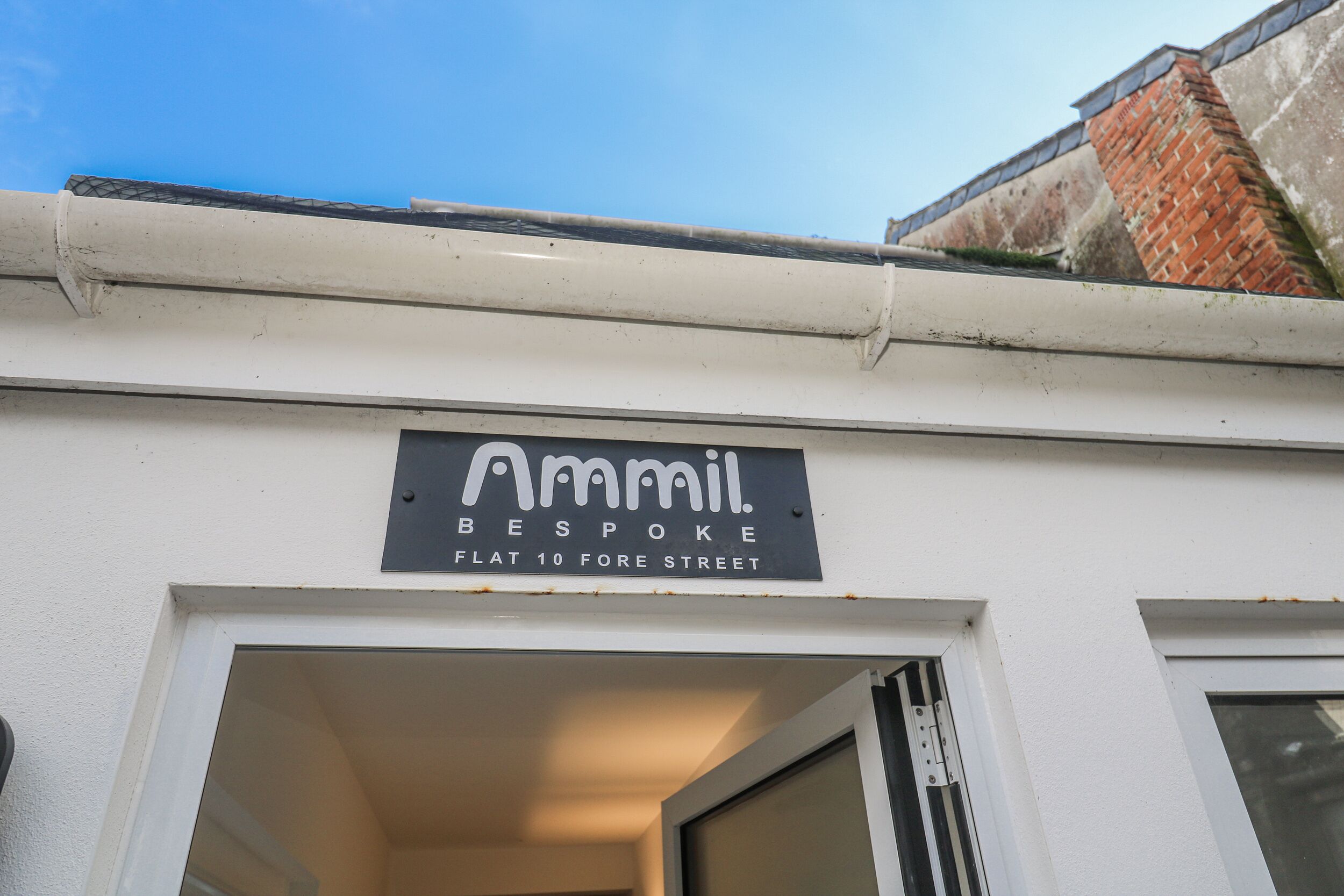 Ein Gebäude mit einem Schild, auf dem 'Amil Bespoke Flat 10 Fore Street' steht.
