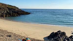 A beach with rocky terrain and a clear view of the ocean. - Ammil Bespoke (St Ives)