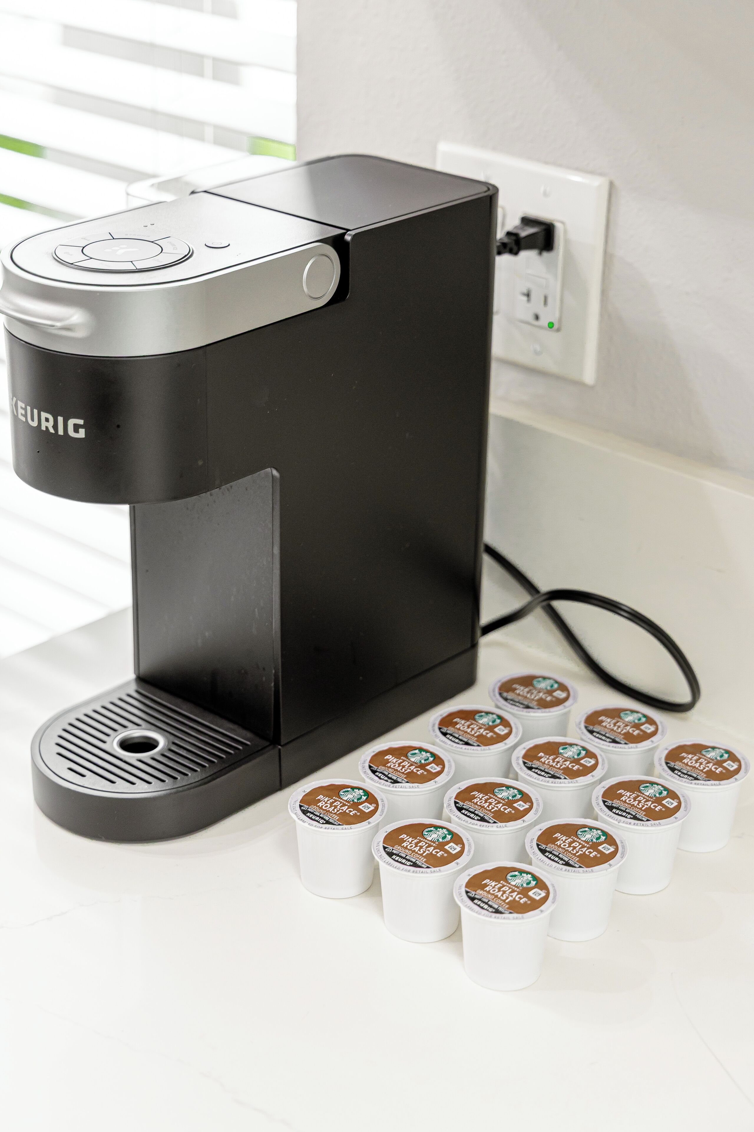 A coffee maker with multiple coffee pods on a white countertop.
