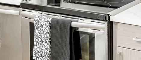 A kitchen with a stainless steel stove, oven, and microwave.