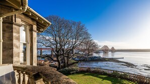 Blick vom Balkon auf einen Fluss mit einer Brücke in der Ferne.