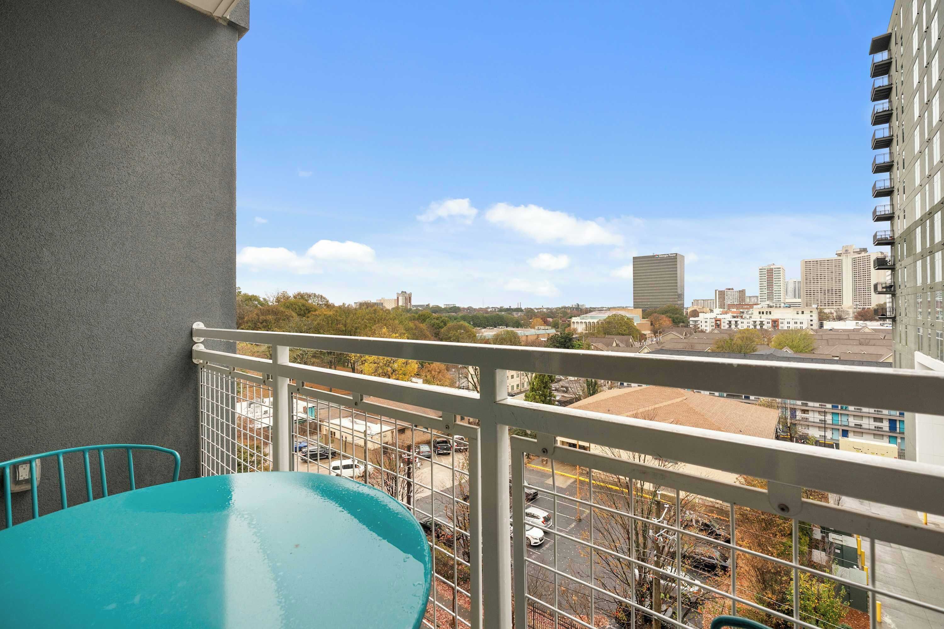 Ein Balkon mit Blick auf eine Stadtlandschaft, einschließlich Gebäude und Bäume.