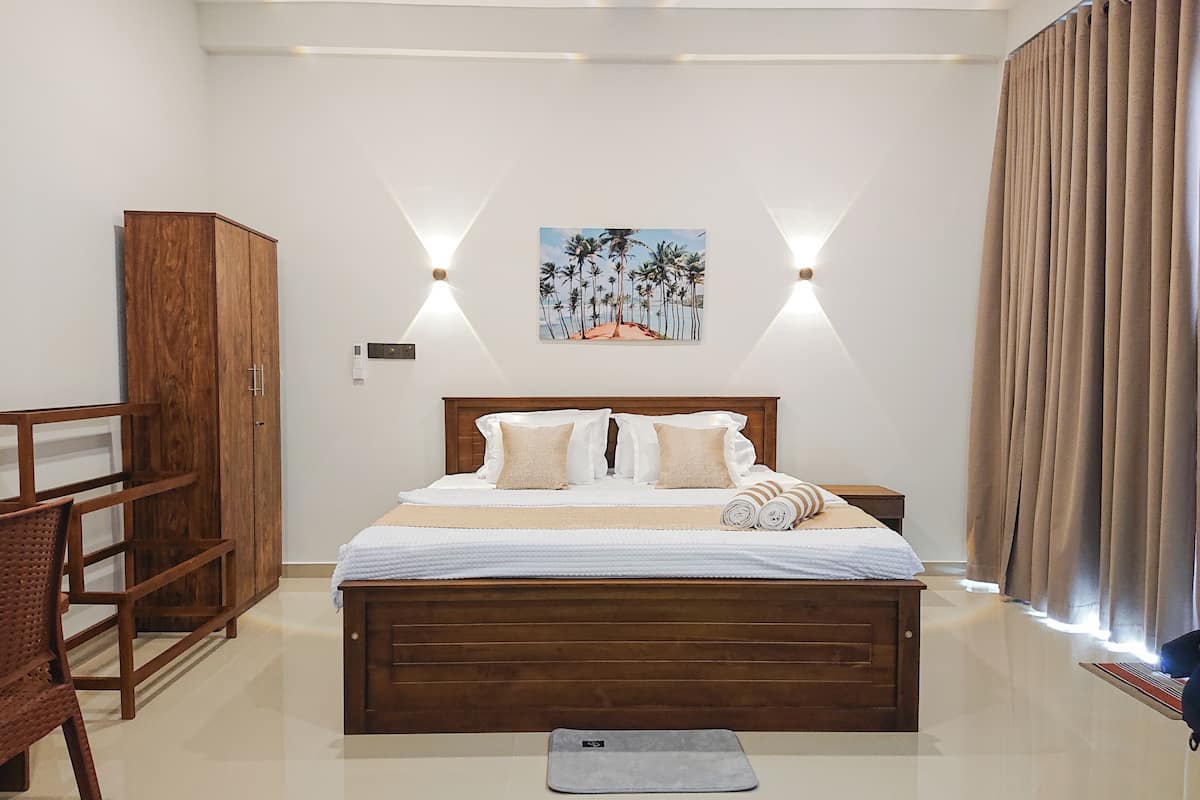 A bedroom with a wooden bed, a nightstand, a desk, and a wardrobe.