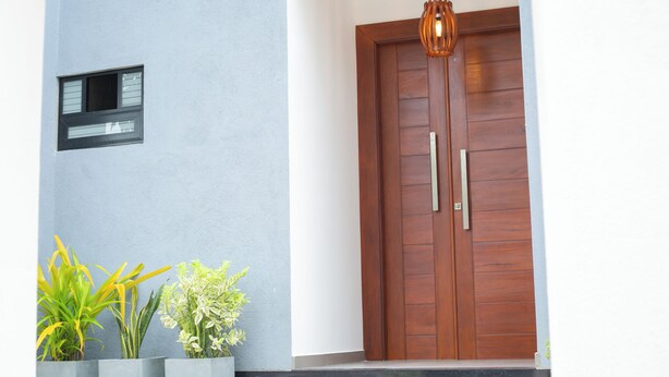 A wooden door with two handles, a small window with a metal grid, and a hanging light fixture. - Crescent Bay Weligama (Weligama)