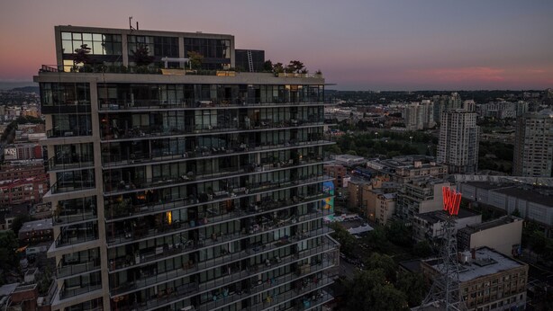 Un edificio de gran altura con varios pisos, ventanas amplias y balcones.