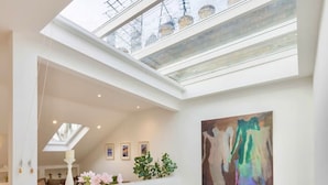 A modern interior with a skylight, a white counter, and a staircase. - Luxury Penthouse in Maida Vale With Fast Wi-fi (London)