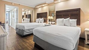 Ein Hotelzimmer mit zwei Betten, einem großen Spiegel und einem kleinen Tisch mit Lampen.