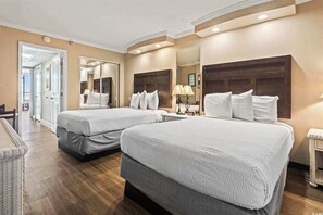 Ein Hotelzimmer mit zwei Betten, einem großen Spiegel und einem kleinen Tisch mit Lampen.