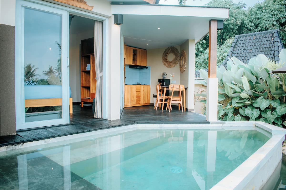 Ein modernes Haus mit Swimmingpool, Essbereich und Küche.