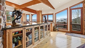 Cocina amplia con armarios de madera, encimera de granito y ventanas grandes con vistas a las montañas.
