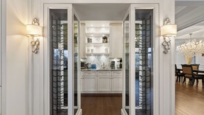 A modern kitchen with white cabinetry, a marble backsplash, and a central island.