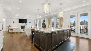 A spacious kitchen with dark cabinetry, a large island, and pendant lighting.