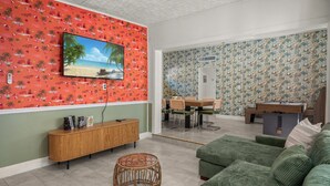 A living room with a TV, a dining area, and a sofa. - Beautiful East Orlando Home Near Everything (Orlando)