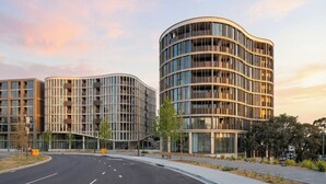 A modern multi-story building with a curved facade, large windows, and a flat roof. - Stylish 1BDR Sunlit Apartment w Rooftop Pool and Gym (Canberra)