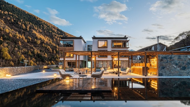 A modern two-story house with a swimming pool, outdoor seating, and a stone wall. - Siguniang Mountain Wind-Waiting Homestay (Ngawa Autonomous Prefecture)
