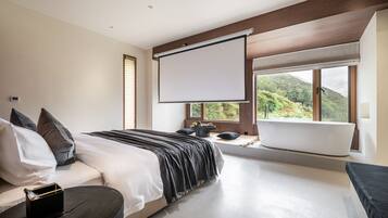 A modern bedroom with a large bed, a bathtub, and a projector screen.