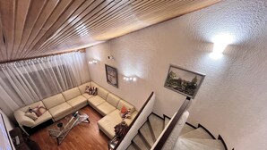 Ein Wohnzimmer mit Ecksofa, Couchtisch und Treppe.