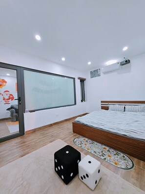 Une chambre moderne avec un grand lit, une porte-fenêtre coulissante et un projecteur fixé au mur.