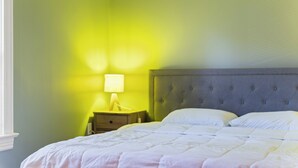Un dormitorio con una cama, una mesita de noche y una lámpara.