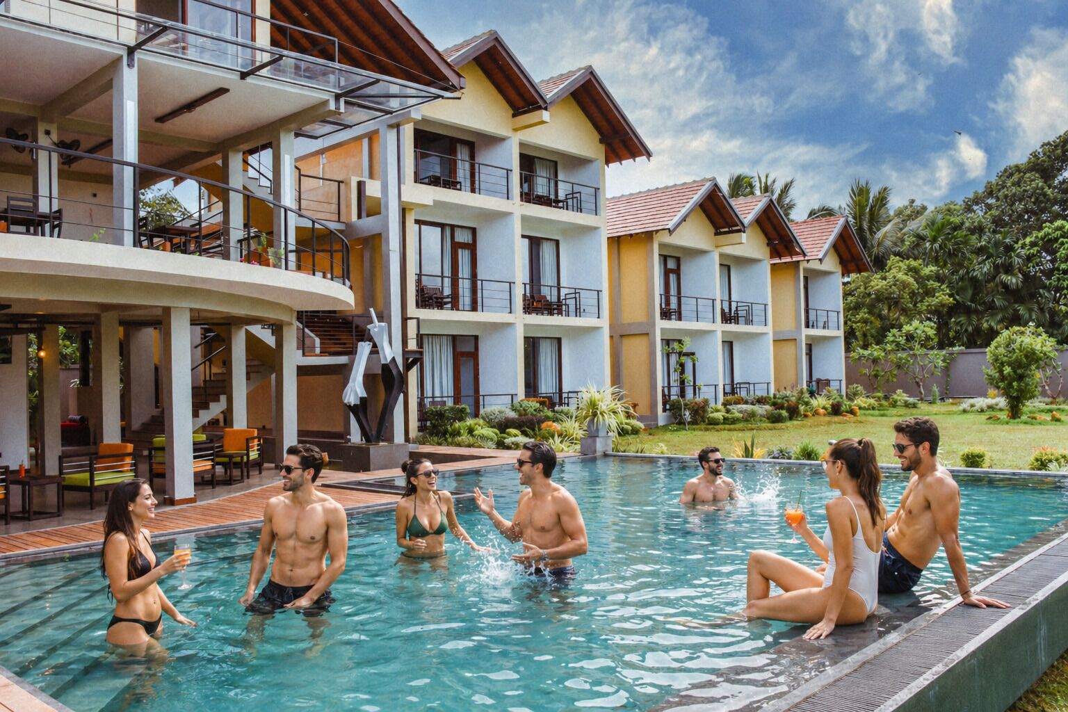 Ein Resort mit Schwimmbad, Sitzgelegenheiten im Freien und einem mehrstöckigen Gebäude mit Balkonen.
