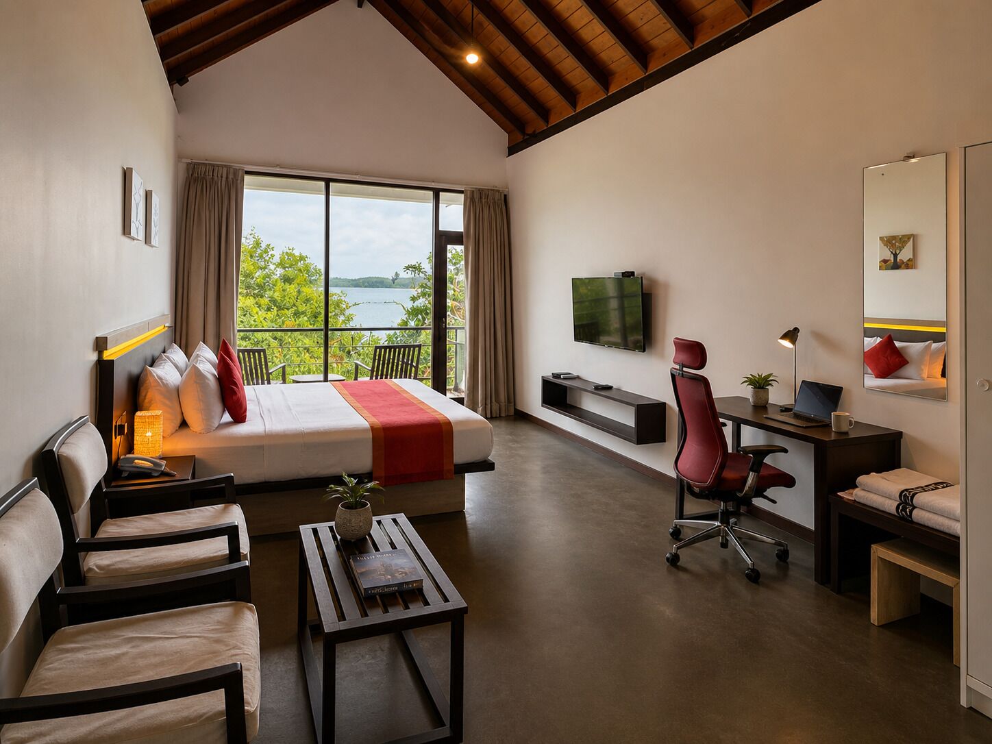 A modern hotel room with a bed, seating area, desk, and a large window offering a view of greenery and water.