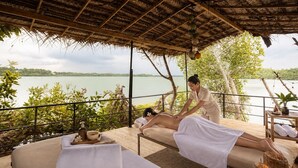 A spa area with two massage tables, a wooden deck, and a view of a lake. - ZEN Koggala Lakefront Boutique Retreat (Harumalgoda)