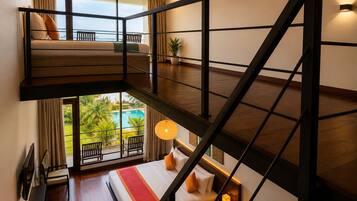 Habitación con varios niveles, balcón, cama, escritorio y vista a una piscina.