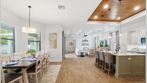 A modern kitchen with wooden flooring, white cabinets, and a central island. - Family Beach Oasis w/ Heated Pool, Spa & Guest House (Bonita Springs)