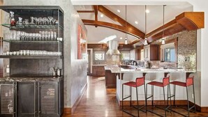 Una cocina moderna con barra, vigas de madera y una isla grande.