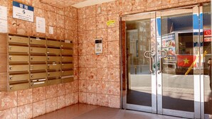 A lobby with a marble wall, a mail drop area, and a glass door entrance. - Have a great time on the top floor with a view of Tsutenkaku Tower from the terrace in the heart of Osaka. 3 minutes from Kuromon Market!  Max. 8 people OK (Osaka city Naniwa-Ward Shimodera)