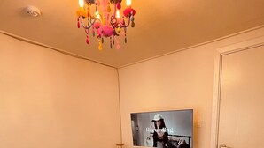 Un comedor con mesa, sillas, televisor y microondas.