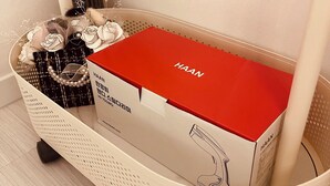 Una cesta blanca tejida que contiene una caja roja con la etiqueta 'HAAN' y una caja negra con texto en coreano.