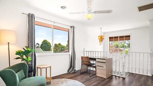 Ein modernes Zimmer mit Schreibtisch, Stuhl und Blick ins Freie.