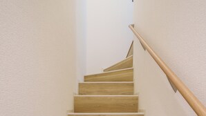 Una escalera de madera con barandilla, que lleva a una plataforma.