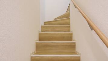 A wooden staircase with a handrail, leading to a landing.