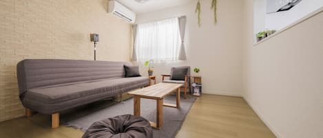 A modern living room with a sofa, a coffee table, and a bean bag.